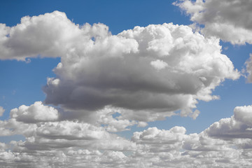 Obraz premium Blue sky and multiple heavy clouds on spring midday. Nature background.