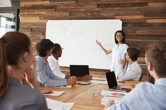 Young Black Woman Giving Business Presentation At Whiteboard