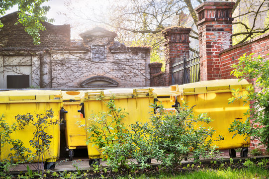 Yellow Dumpster Standing On An Inner Yard