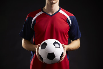 Close Up Of Professional Soccer Player With Ball In Studio