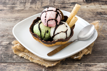 Ice cream scoops served in waffle basket on  wooden table
