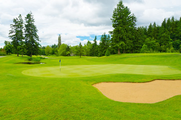 Fototapeta premium Golf course with gorgeous green and sand bunker