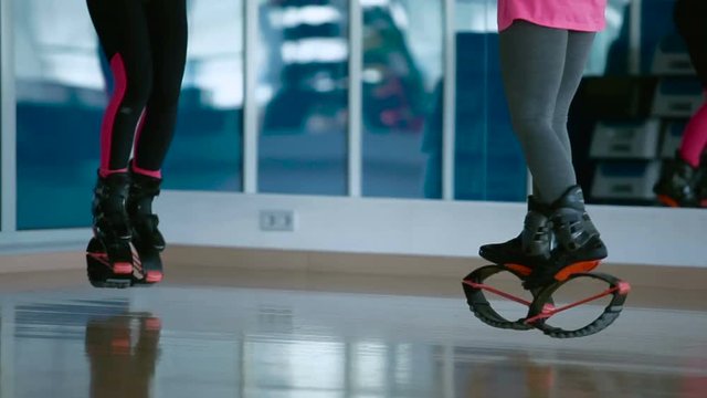 Two girls jumping in kangoo shoes in the dance studio