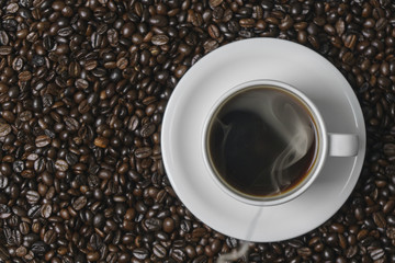 Cup of coffee on  coffee beans background.