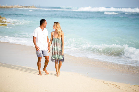 Content Couple Chatting and Walking on Beach