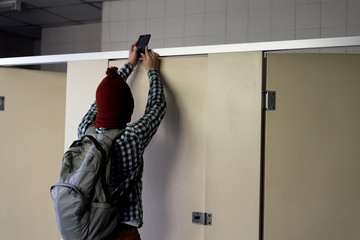 criminal take photo and record video in public toilet.