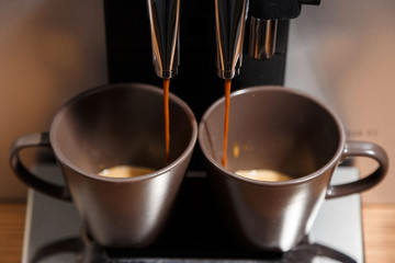 Espresso machine pouring coffee in two cups