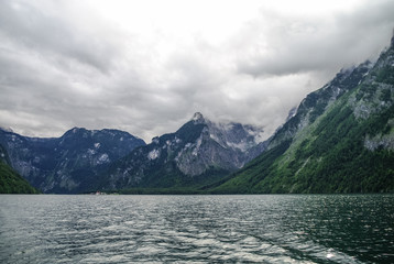 Low clouds over forest and mountains on bank of lake Koenigssee, Bavaria, Germany