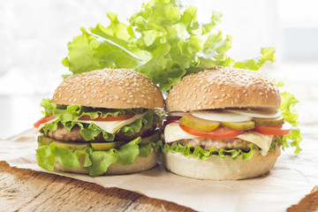 Homemade hamburger with fresh vegetables on a wooden background