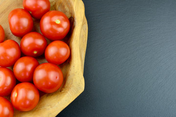 Tomaten - Cocktailtomaten in einer Holzschüssel mit Textfreiraum
