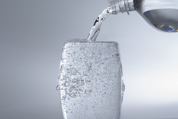 Wasser in Glas einfüllen aus Flasche - überfüllen