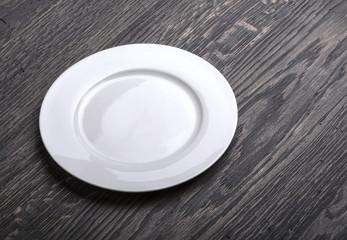 Empty white plate on wooden