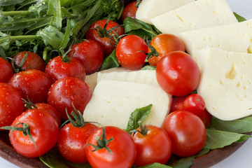 Suluguni cheese, tomatoes and ruccola close up