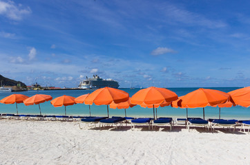  beach chairs and  white umbrellas on caribbean island St. Marten