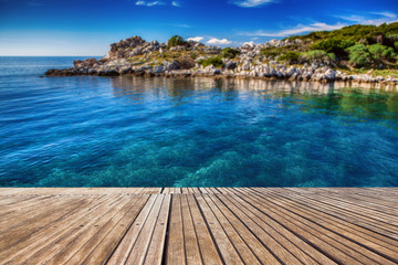 Beautiful beach and old wooden pier with crystal clear sea. Berth to the shore. Summer concept. Island on the background