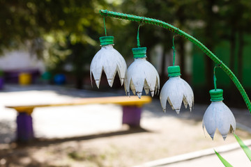 Flower lily of the valley made of white plastic bottles in the garden Decor of plastic bottles