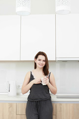 Fototapeta na wymiar young woman With black hairdrinking coffee in the kitchen