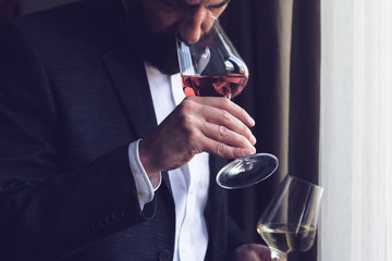 man tasting a glass of rose wine - obrazy, fototapety, plakaty