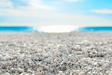 Fototapeta na wymiar On the Beach by the Sea - beautiful white pebble beach at the mediterranean coast on a beautiful day