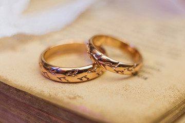 Gold wedding rings on the vintage book. Close-up