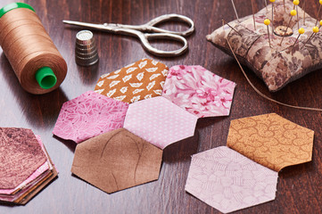 Fototapeta na wymiar Sewing of hexagon pieces of fabric a quilt Grandmother's Flower Garden