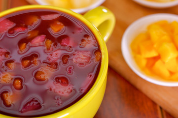 Yellow bowl with traditional tasty latin american colada morada berry juice, symbolizing blood from those deceased, day of the dead concept