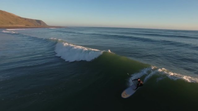 Standup paddle board surfing (SUP) a wave, aerial view New Zealand