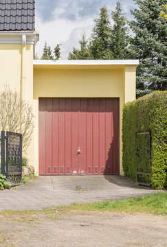 Rotes Garagentor mit gelber Fassade 