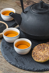 The teapot and tea on the wooden table, delicious snacks