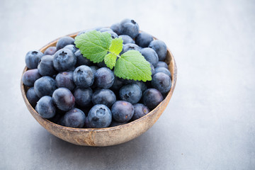 Fresh blueberries natural coconut in a bowl on a gray background.