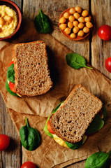 rye sandwiches with hummus, spinch and tomatoes
