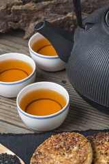 The teapot and tea on the wooden table, delicious snacks