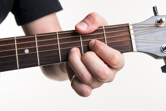 The guitarist's hand clamps the chord D on the guitar, on a white background. Horizontal frame