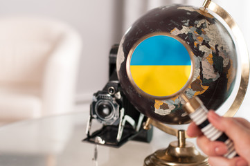  Ukrainian flag on globe under magnifying