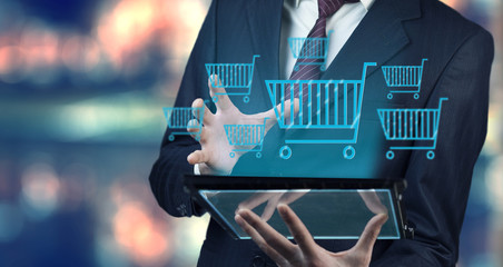 Businessman hand tablet and  shopping basket icon © ARAMYAN