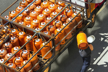 gas bottles with butane in truck with  worker for delivery , lpg  glp - obrazy, fototapety, plakaty