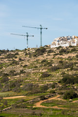 Cranes tower over Mellieha in the northern part of the island of malta.