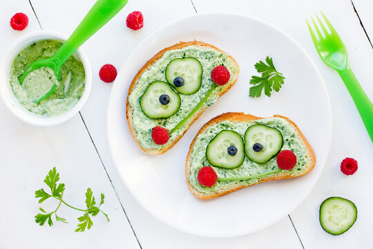 Fun frog sandwich with green parsley pesto cucumber and raspberry for kids