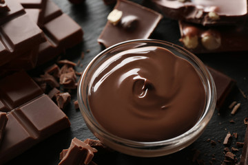 Bowl with melted chocolate and chopped bars, closeup