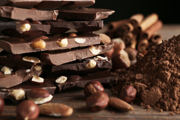 Chopped chocolate bars with nuts and cocoa powder, closeup