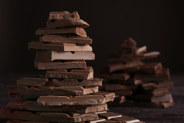 Chopped chocolate bars on dark background, closeup