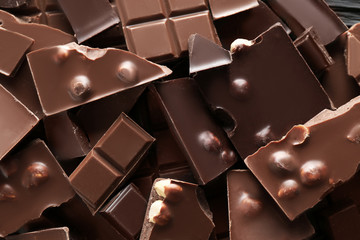 Chopped chocolate bars with nuts as background