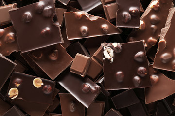 Chopped chocolate bars with nuts as background