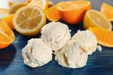 Delicious balls of citrus ice-cream on dark wooden background