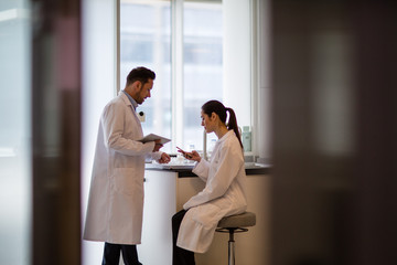 Female scientist discussing results of experiment with male colleague