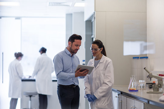 Female scientist discussing data with pharmaceutical sales rep