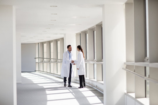 Doctors shaking hands in hospital corridor