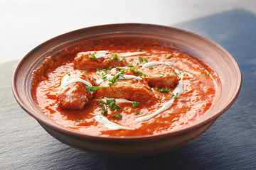 Delicious Murgh Makhani in bowl on grey background