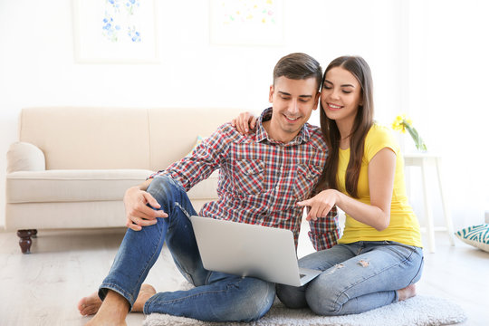 Happy young couple with laptop at home