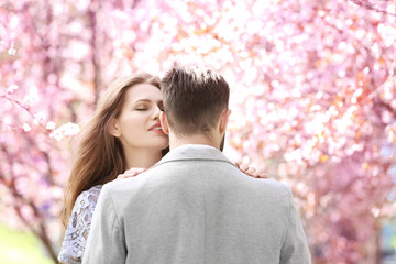 Young lovely couple walking in spring park